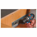 Person using a Bosch drill and angle chuck to install trim on a wooden wall.
